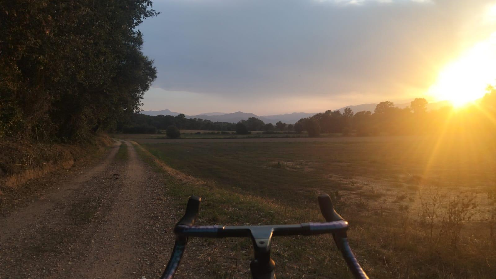 Ciclista en ruta de gravel a la posta de sol, prop de Can Freu